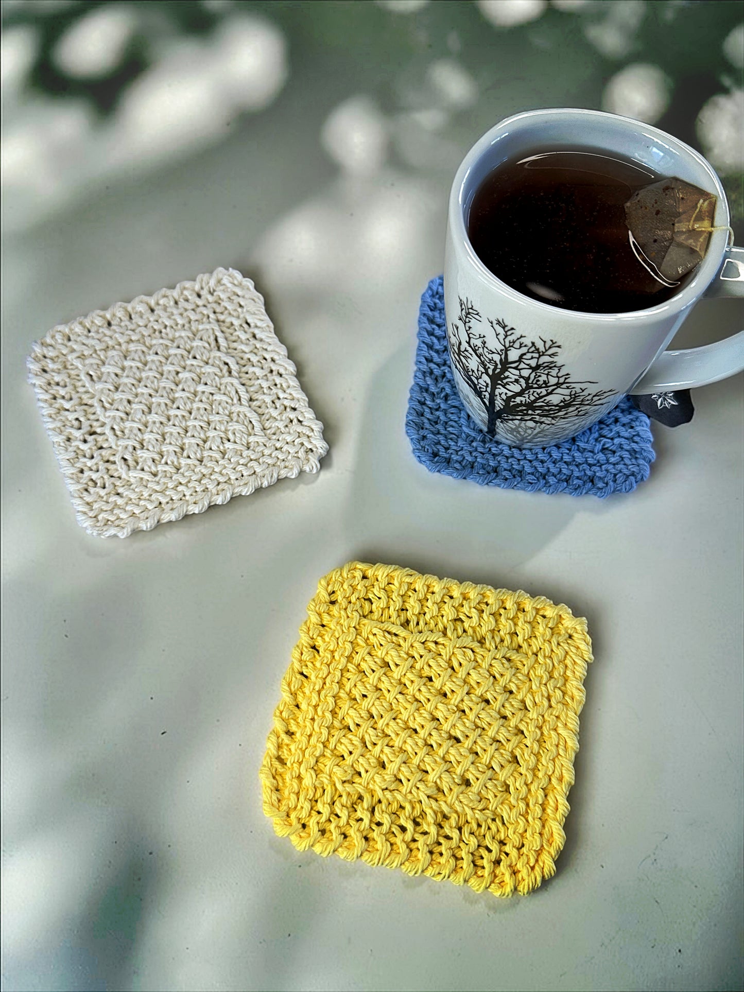 Beginner friendly knit coaster pattern with step by step photos showing crossed stitch texture and flat edges