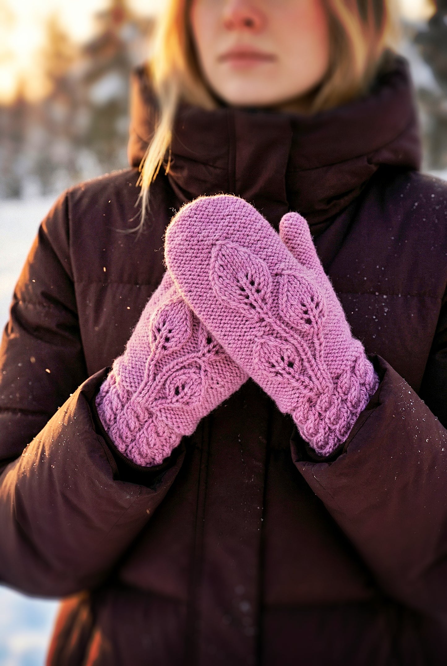 Person wearing purple knitted mittens in a snowy setting